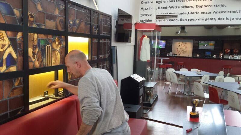 Monteur werkt aan de glaspanelen in de kantine