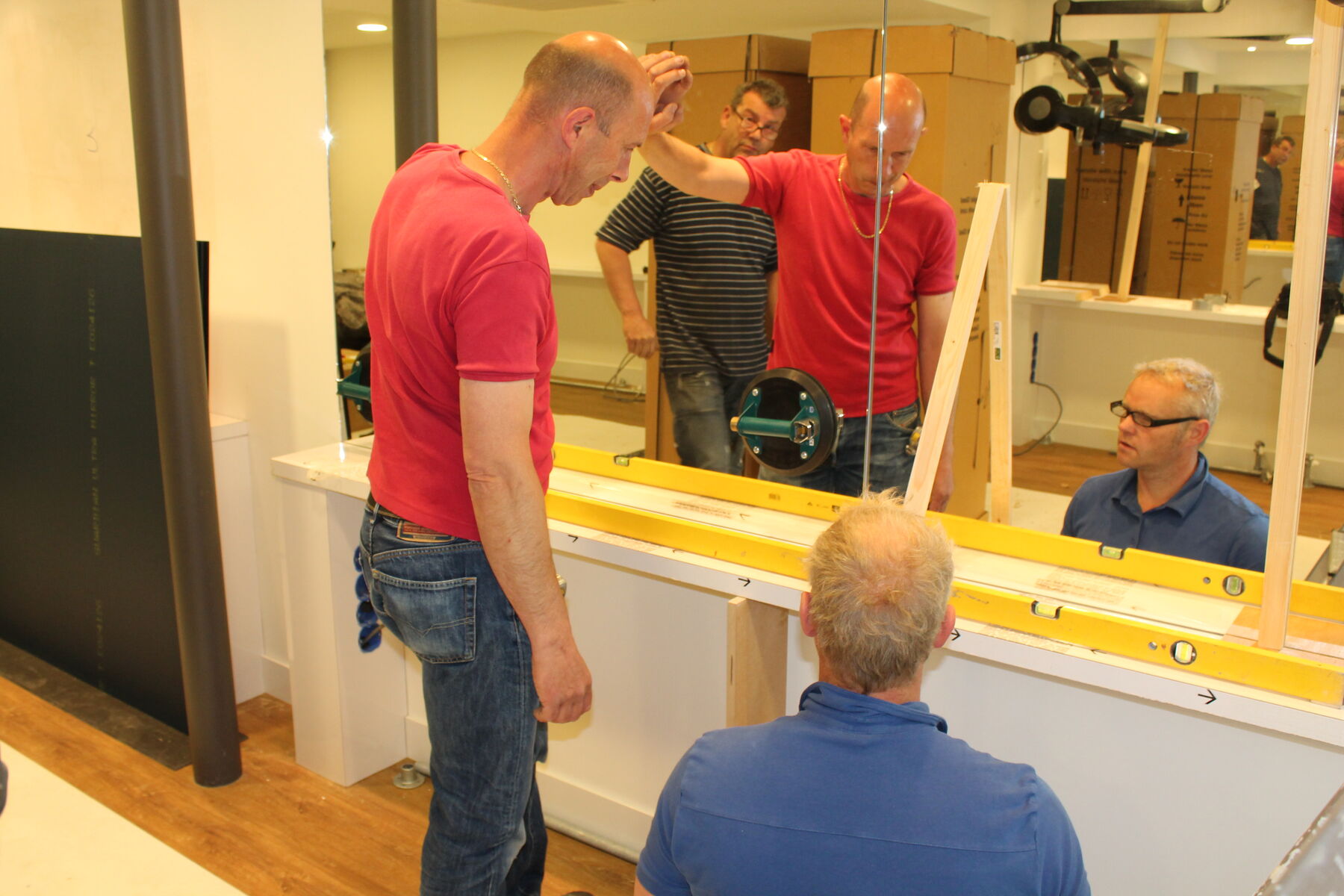 Montage van grote spiegels in een kapsalon in Oostzaan