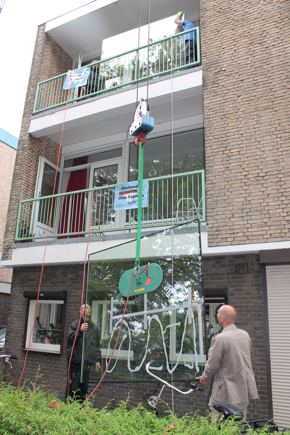 Groot isolatieglas wordt op hoogte geplaatst in Amsterdam