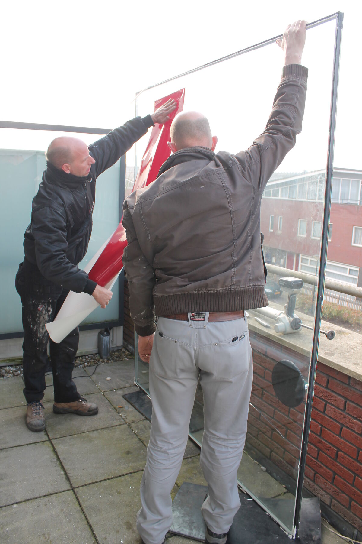 Monteurs zetten de grote ruit op het balkon