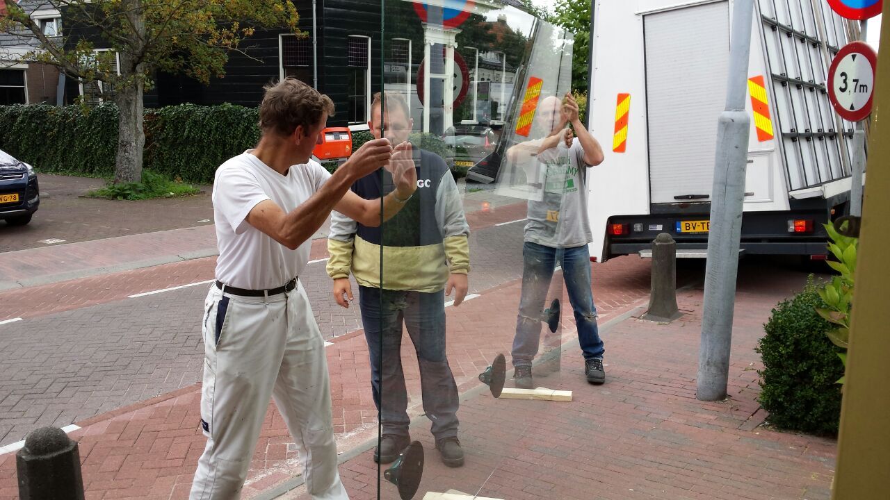 Monteurs brengen een gelaagde ruit naar binnen