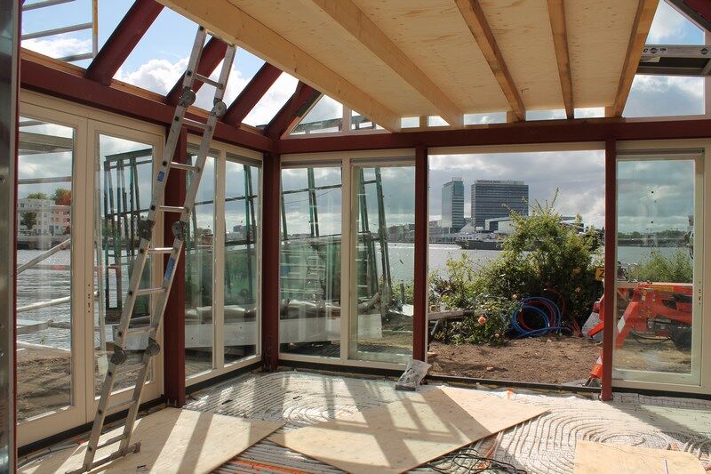 Interieur van het glazen huisje met uitzicht op het water
